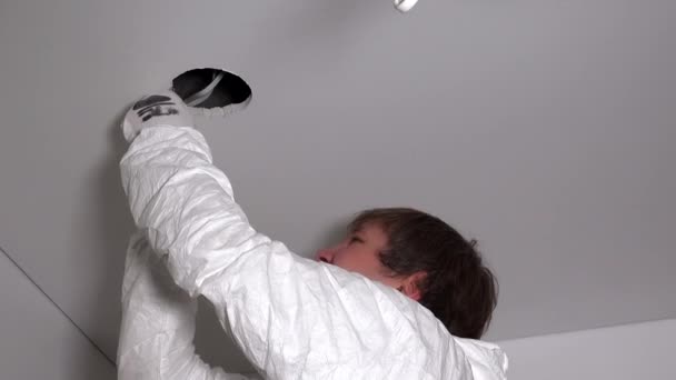 Young man cutting hole in plasterboard ceiling — Stock Video