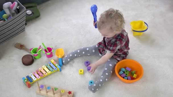 Niña colocando bloques de colores en el tazón. Juego en la habitación. 4K — Vídeo de stock