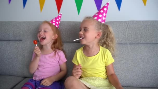 Beste Freundin Schwestern Party zu Hause. rothaarige und blonde Mädchen lachen vor dem Fernseher — Stockvideo