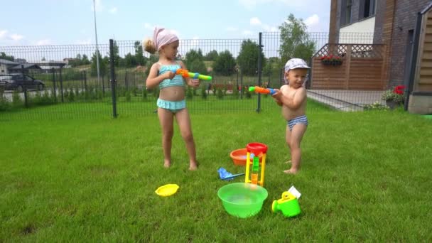 Madre traer agua para sus hijos jugando lucha de agua en el patio trasero — Vídeos de Stock
