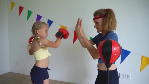 Sevgi dolu annesiyle boks antrenmanı yapan aktif küçük bir kız. Mutlu aile kızları — Stok video