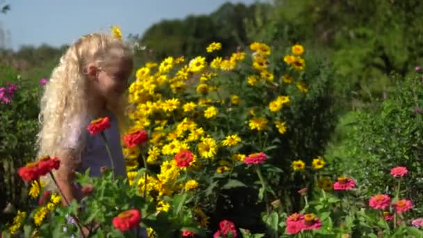 Kleines Engelskind mit Blume im Kopf, das zwischen bunten Blumen wandelt — Stockvideo