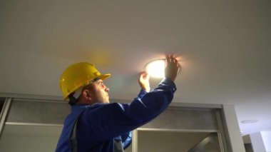 Elektrikçi tavan lambasını sökmüş ve kablo bağlantılarını incelemiş.