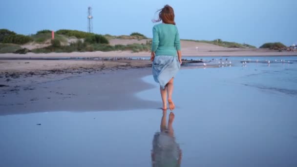 穿着连衣裙在海滩海岸线上奔跑的活跃女人 — 图库视频影像