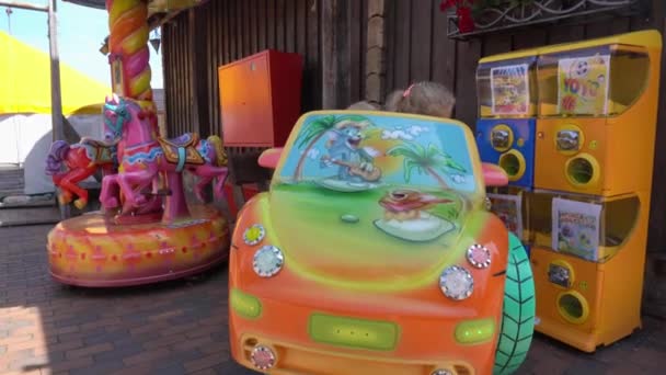 Feliz familia madre e hijo con hija girar en carrusel de coche. Movimiento de cardán — Vídeos de Stock