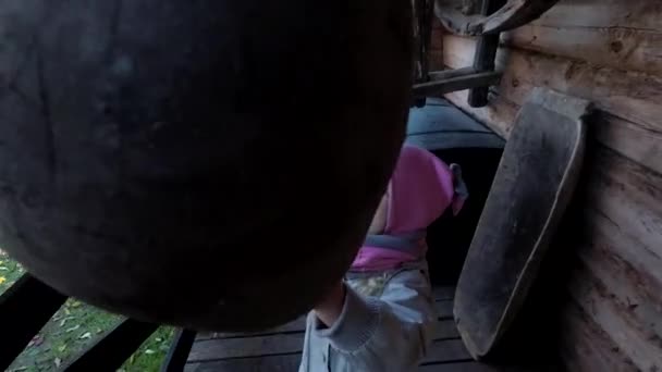 Κοριτσάκι που κρατάει μια μεγάλη ξύλινη κουτάλα. Η μητέρα με τα παιδιά παίζουν. — Αρχείο Βίντεο
