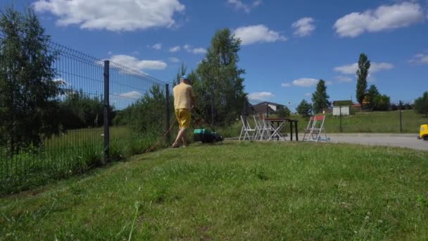 Person klippa bakgård gräsmatta med gräsklippare. Bordsstolar och brödrost. Gimbal Ordförande — Stockvideo