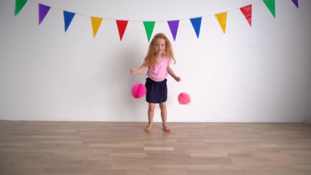 Creative little girl pretending cheerleader holding pink pompon paper balls Royalty Free Stock Video