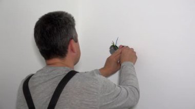 Yetenekli elektrikçi tornavidayla elektrik prizi kurar