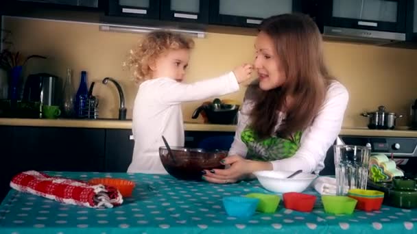 Mère et fille ont mis de la pâte au chocolat sur le nez. Heureuses filles de la famille jouer — Video