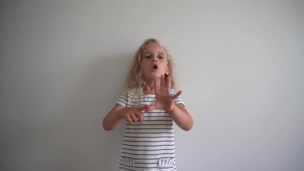 Emotional female kid counting her fingers over white background. Gimbal shot — Stock Video