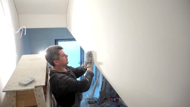 Arbeiter schleift Wand mit Schleifpapier — Stockvideo