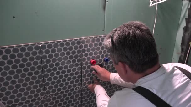 专业杂工在瓷砖上做记号以扩大孔洞 — 图库视频影像
