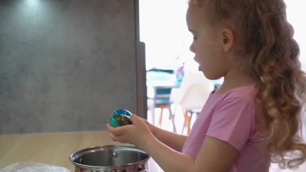Excited blond girl look at painted colorful Easter eggs and camera. Gimbal shot — Stockvideo