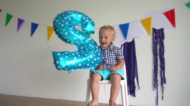 Brincalhão masculino criança sorrir e jogar com número dois balão na festa de aniversário — Vídeo de Stock