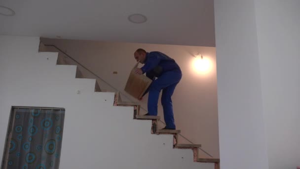Carpenter man install ash board step on new apartment staircase — Stockvideo