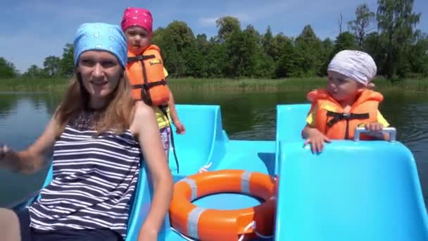 Zoon dochter en moeder in reddingsvesten drijven op catamaran boot. Gimbal beweging — Stockvideo