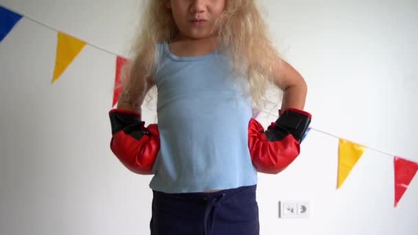 Забавный кавказский ребенок в боксерских перчатках перед камерой. Медленное движение — стоковое видео