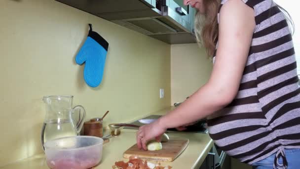 Gravid kvinna händer hugga lök glödlampa i köket — Stockvideo