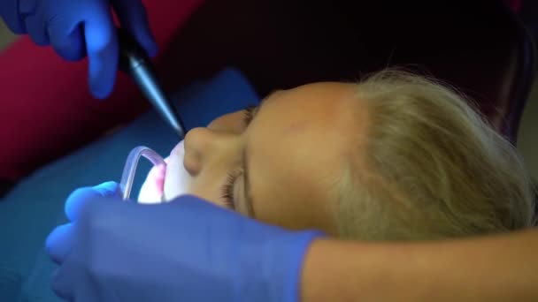 Kleines Mädchen nach der Zahnbehandlung beim Zahnarzt. Mutiges Kind lächelt — Stockvideo