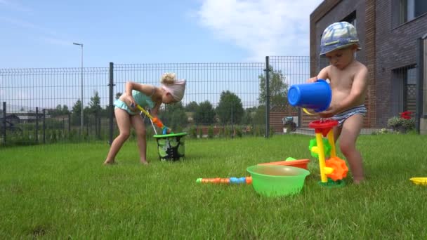 Freche Mädchen schießen auf ihren kleinen Bruder mit Spielzeug Wasserpistole und er läuft weg — Stockvideo