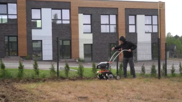 Tuinman vernieuwt grond voor gazon zaaien in prive-huis werf. Gimbal motie — Stockvideo