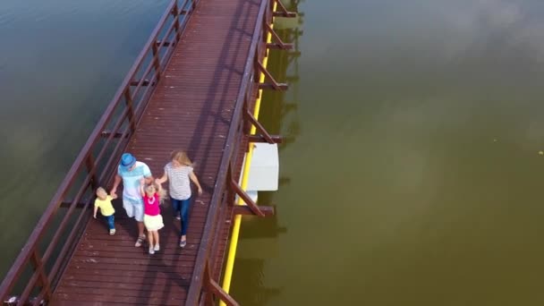 Αεροφωτογραφία της οικογένειας να περπατά μαζί στη γέφυρα. Μπαμπά, μαμά με γιο και κόρη. — Αρχείο Βίντεο