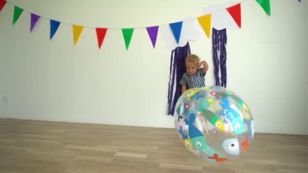 Baby boy spelen met grote opblaasbare bal. Grappig kind, veel plezier. Gimbal motie — Stockvideo