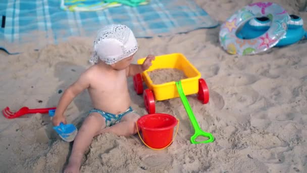 Batole dítě hrát s pískem a hračky na pláži. Koncept rodinné dovolené — Stock video
