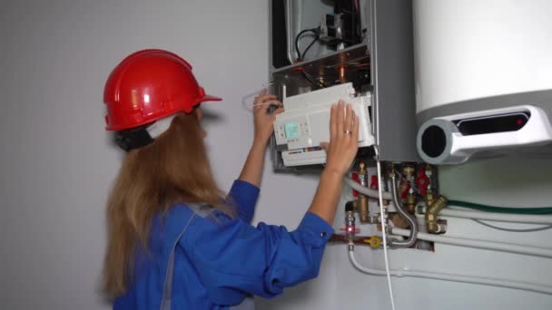 Professional worker girl servicing the gas boiler for hot water and heating — Stock Footage Professional worker girl servicing the gas boiler for hot water and heating Royalty Free Stock Video