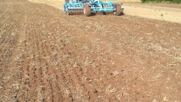 Agriculture machine tractor discing stubble field. cultivating farm land soil. — Stock Video