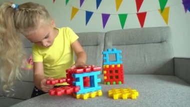 Koltukta renkli yapıcı parçalarını birleştiren sevimli bir kız. Gimbal hareketi