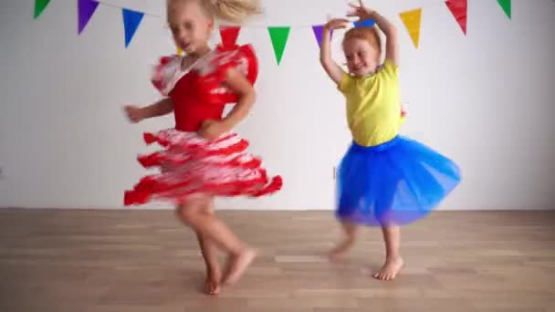 Gekke roodharige en blonde meisjes die dansen op een feestje. stoute kinderen veel plezier — Stockvideo