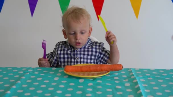 Рука дает морковку для ребенка. Мальчик порезал неочищенную морковь ножом. Гимбальное движение — стоковое видео