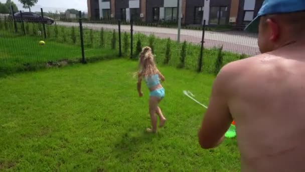 Lekfull far stänk vatten på sin dotter flicka med vattenpistol — Stockvideo