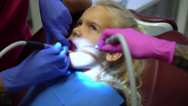 Les mains du docteur travaillent avec la perceuse. Enfant bouche ouverte pendant le perçage des caries dentaires — Video