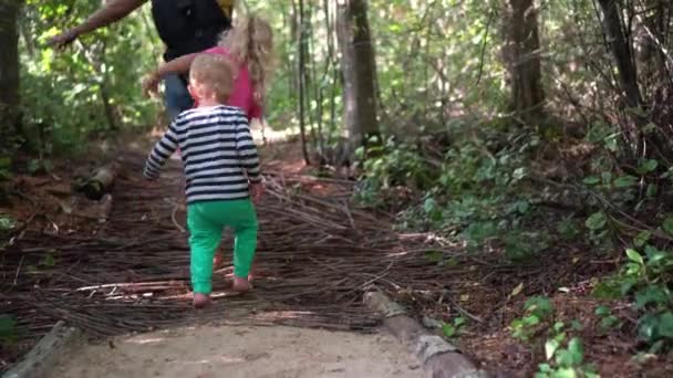 Descalzo niños niño, niña y madre piernas caminar en madera palos camino — Vídeos de Stock