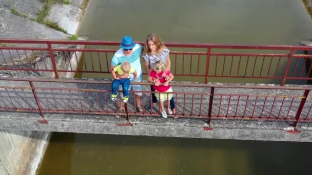 Padres adultos con niños admirando la vista abandonada de la presa. Movimiento aéreo de drones — Vídeos de Stock
