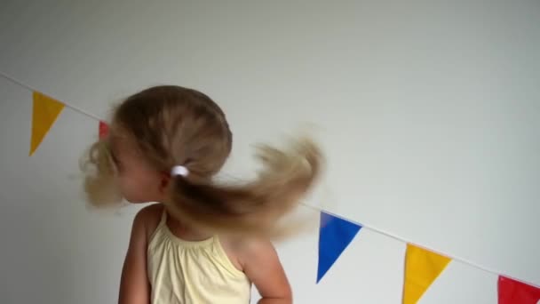 Blond funny child girl shake head with curly hair pigtails. slow motion shot — ストック動画