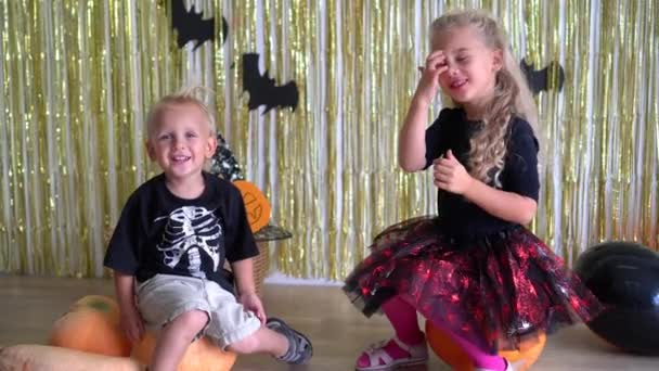 Sorrindo engraçado celebradores halloween crianças no quarto decorado — Vídeo de Stock