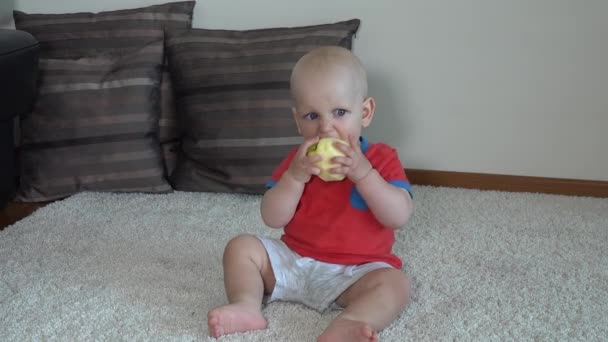 Cute baby boy eating peeled apple. Cute face kid eat healthy fruit food — Stockvideo