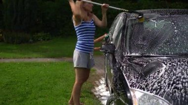 Woman and little girl washing car automobile outdoor