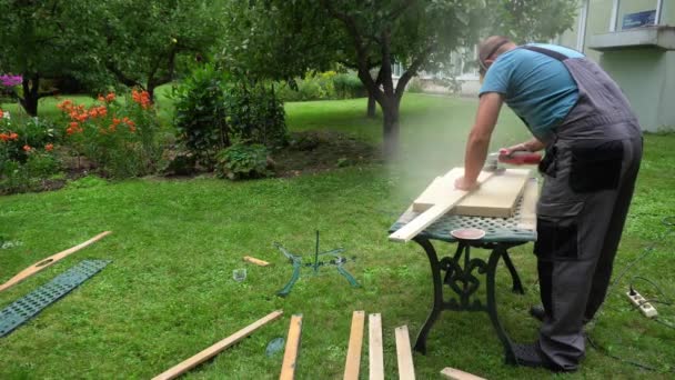 Trabajador con máscara protectora y gafas puliendo tableros de madera con amoladora — Vídeos de Stock