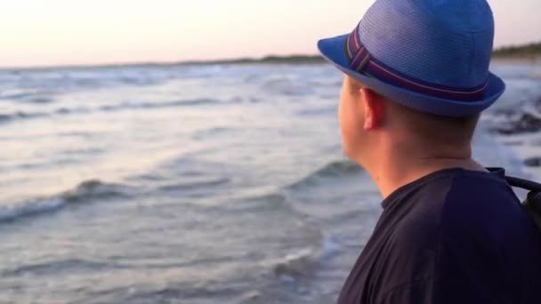 Hombre divertido en sombrero admirando increíble puesta de sol de la noche y sonriendo mirando a la cámara — Vídeo de stock