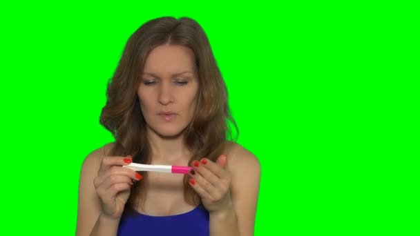 Sad serious young woman with pregnancy test in hands — Stock Video