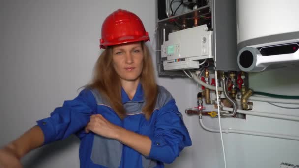 Mulher modelo brincalhão com capacete fingindo como técnico especialista caldeira a gás — Vídeo de Stock
