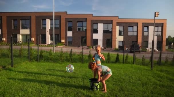 Carino sorelle ragazze spruzzi d'acqua l'uno sull'altro con fucili ad acqua in cortile — Video Stock