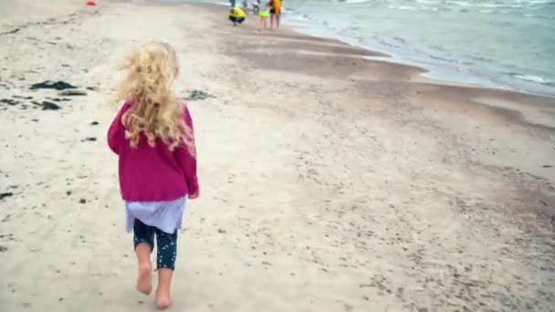 Ragazza bionda che corre lungo la costa. Bello bambino attivo buon divertimento — Video Stock