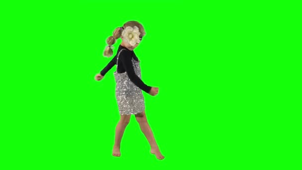 Sarışın bir kız çocuğu yeşil arka planda dönüp dans ediyor. — Stok video
