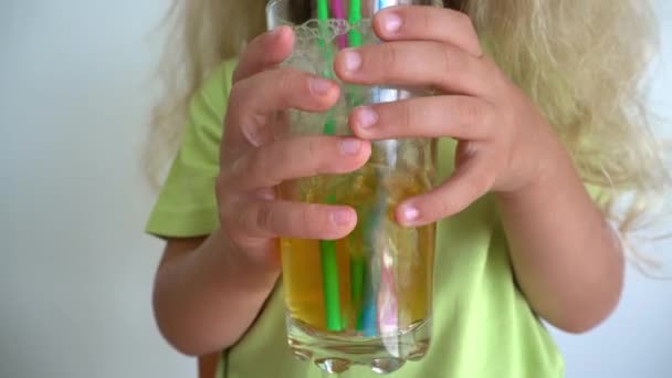 Child making bubbles in glass of apple juice with straws. Gimbal motion — Stok video